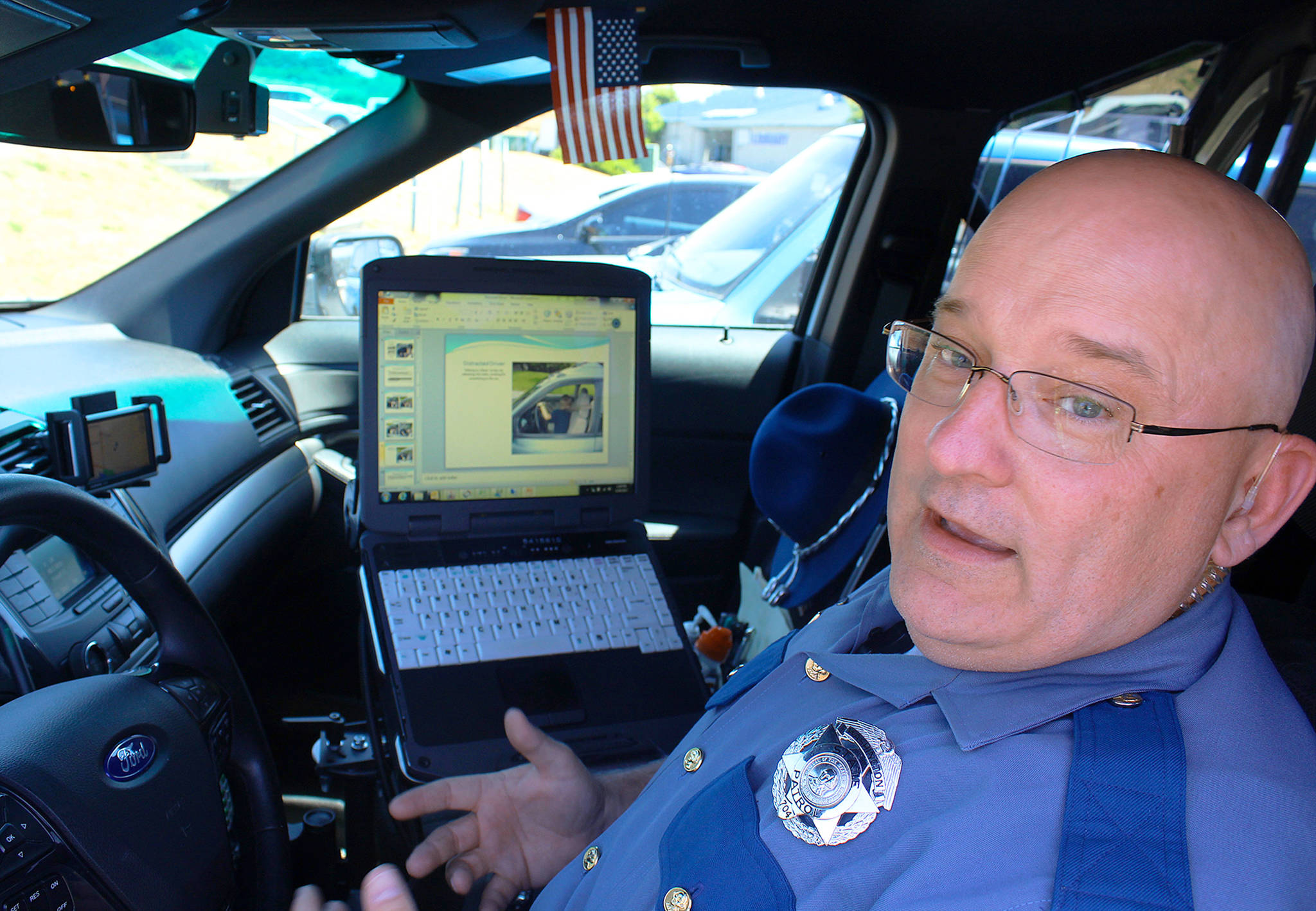 Beginning Sunday it’s illegal under a new state law to have a cell phone or any electronic device in your hand while driving. State trooper Dave Martin advises: “Just focus on getting from point A to point B.” Photo by Patricia Guthrie/Whidbey News-Times