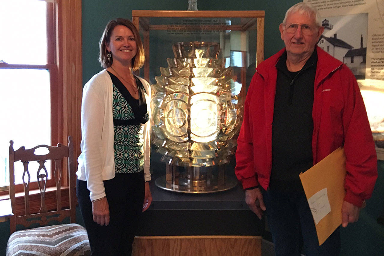 Sharon Young-Hale and Bill French stand near the now-rotating Fresnel lens French built and installed a new mechanism for as a donation to the lighthouse. Photo provided