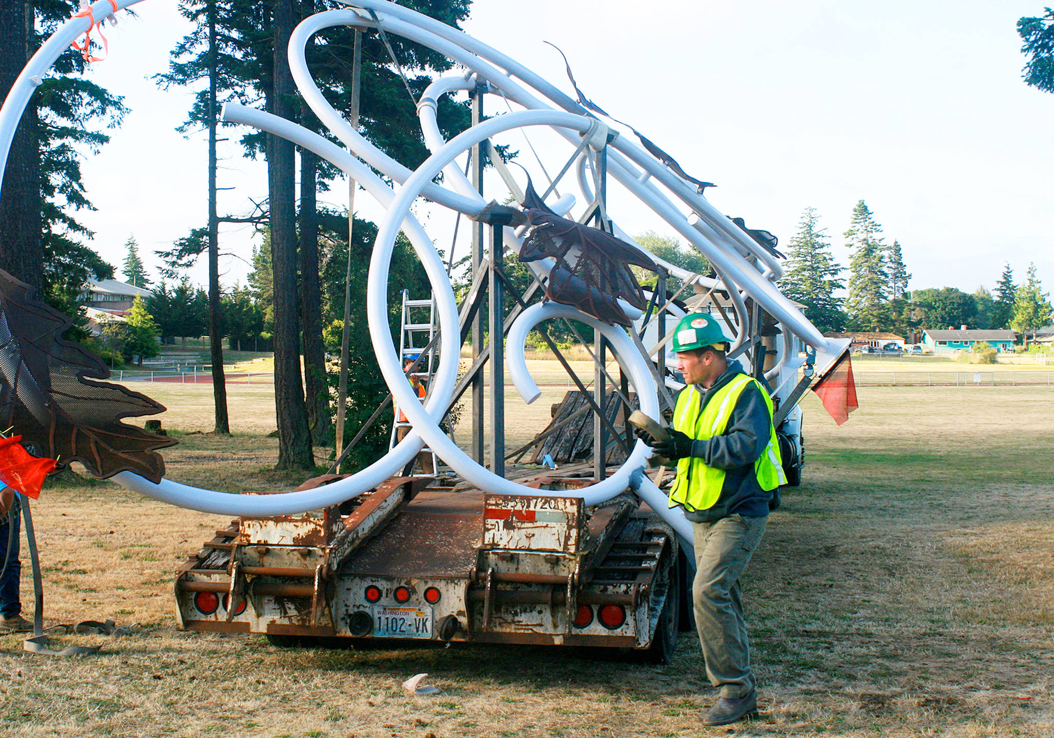Justin Hunter, with Architectural Elements, helps prepare the “Autumn Leaves” sculpture for installation Tuesday morning, along Highway 20, near the North Whidbey Middle School play fields. Photo by Daniel Warn/Whidbey News-Times