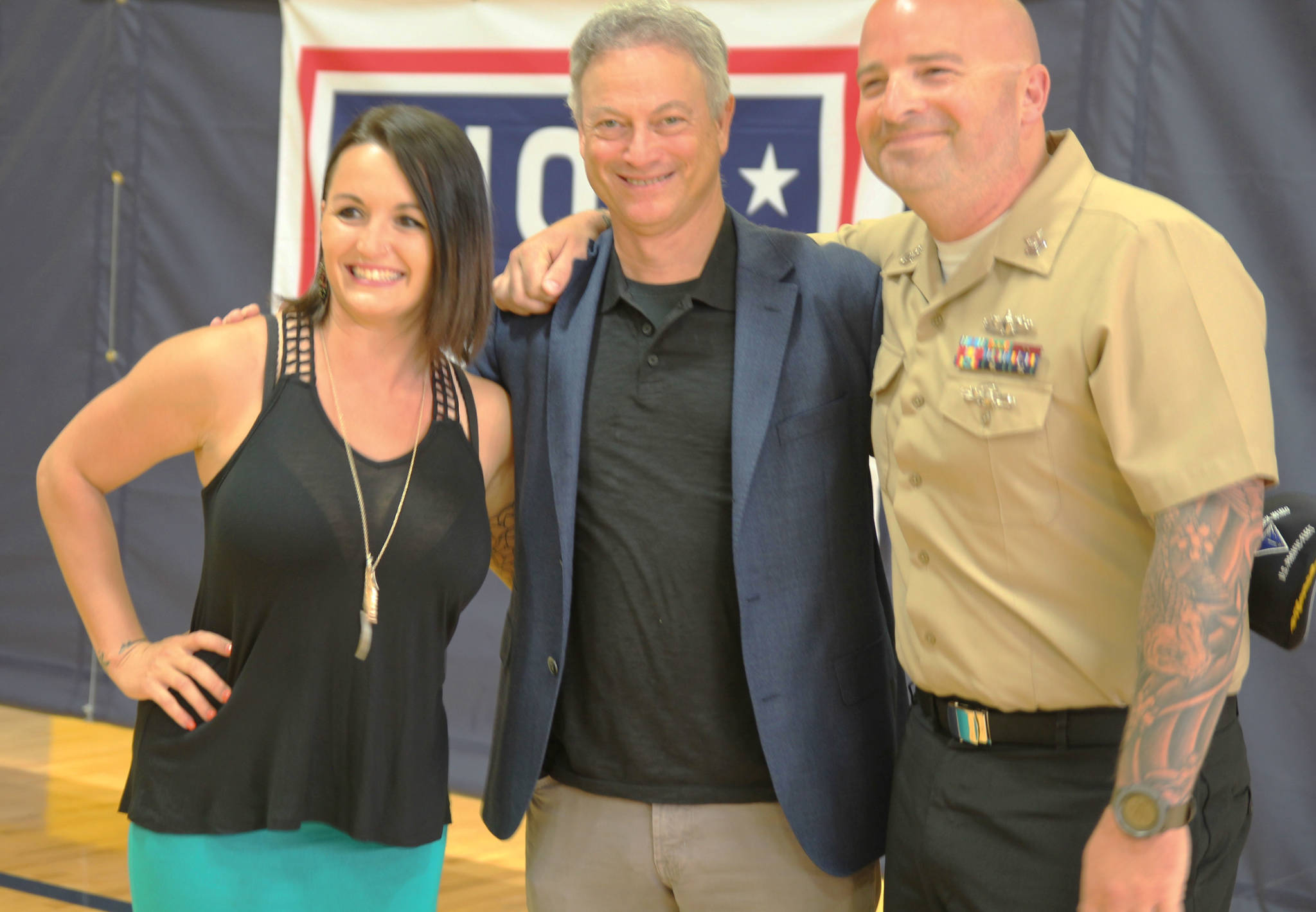 Actor, musician and humanitarian Gary Sinise poses with Tobias and Kimberly Stiewing after participating in a promotion ceremony at Naval Air Station Whidbey Island. Stiewing asked to be “pinned” by Sinise before he performed with the Lt. Dan Band at an outdoor base concert sponsored by USO and Gary Sinise Foundation. Photo by Patricia Guthrie/Whidbey News Times