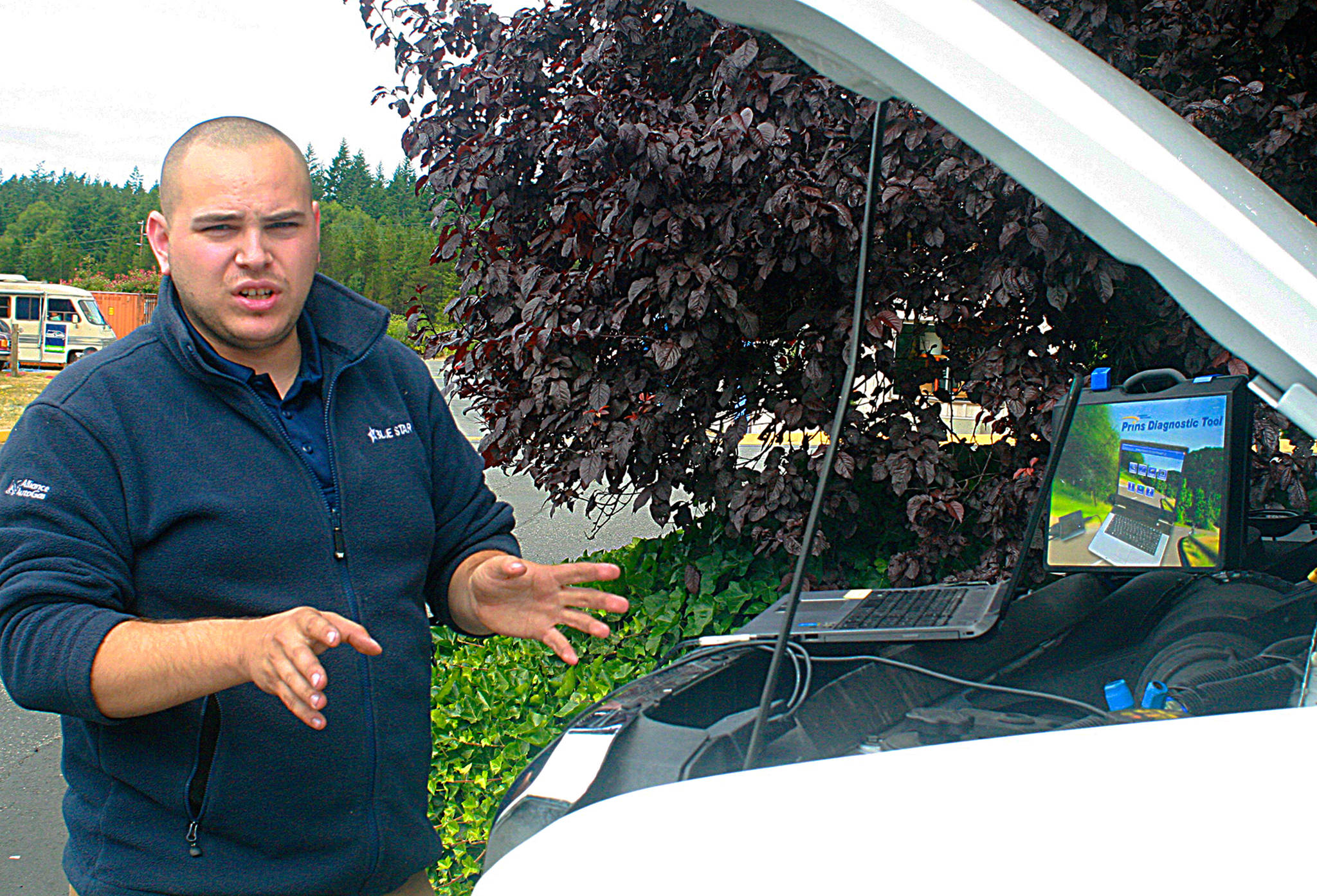 Camryn Engle, autogas coordinator for Blue Star Gas, explains Thursday how added components vehicles converted to propane can by accessed and analyzed locally or remotely by technicians. Whidbey-SeaTac Shuttle & Charter is in the process of converting its entire fleet to propane. Photo by Daniel Warn/Whidbey News-Times