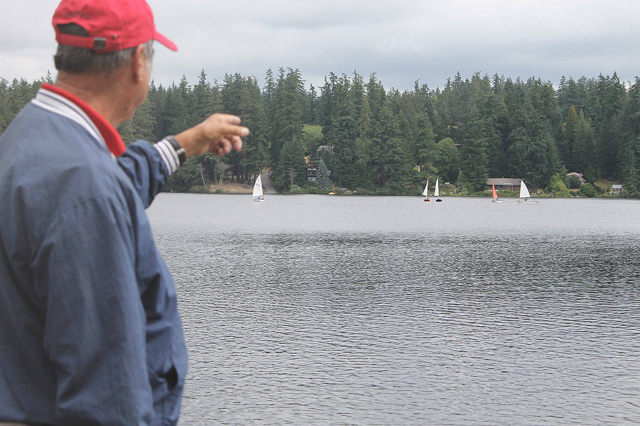 Bob Rodgers, commodore of the South Whidbey Yacht Club, gestures to a class of youth sailors at Goss Lake onThursday. Sailors have moved to Goss Lake due to a toxic algae bloom at Lone Lake. Photo by Evan Thompson / Whidbey News Group