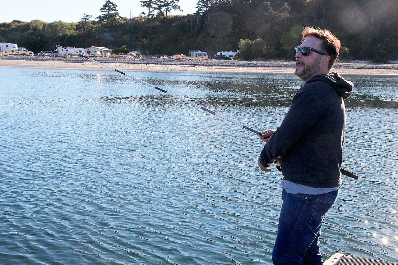 Monday at dusk, Brian Corbett casts his line from a dock near Coupeville Ferry Landing. Nothing came back, no pinks, no silvers, no dinner. &ldquo;I guess we&rsquo;re just out here fishing for compliments,&rdquo; said the visitor from New Jersey. Photo by Patricia Guthrie/Whidbey News-Times