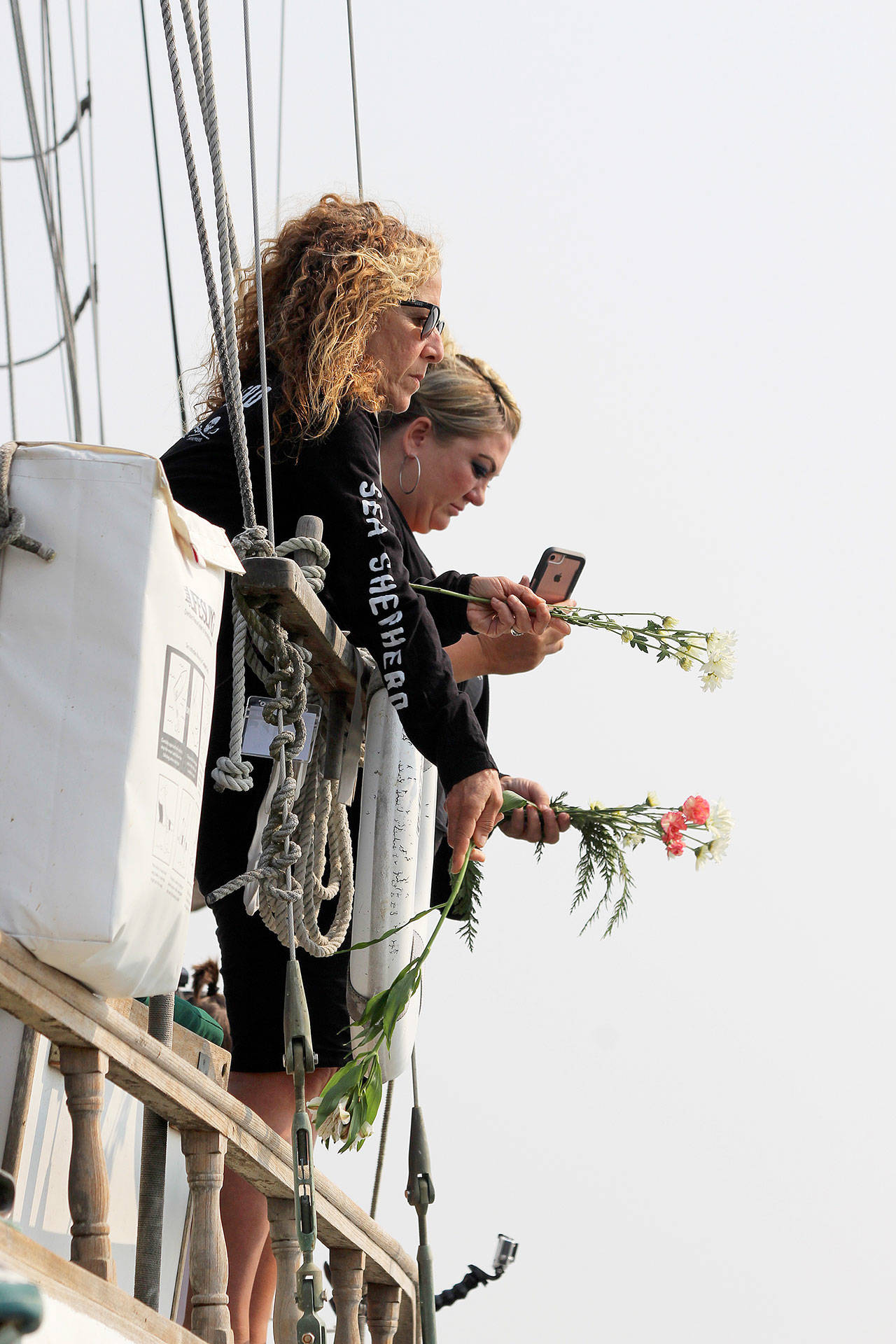 One of two sailboats filled with people who marked the occasion of the Penn Cove whale round-ups on Tuesday with flowers and other tributes. Photo by Patricia Guthrie/Whidbey News Times
