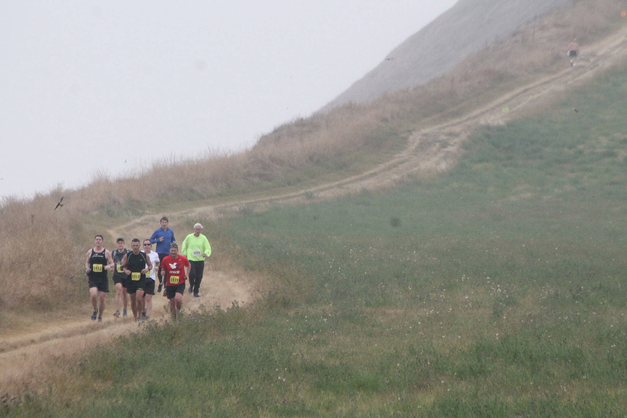 Runners jog through the fog on the bluff trail Saturday. (Photo by Jim Waller/WhidbeyNews-Times)