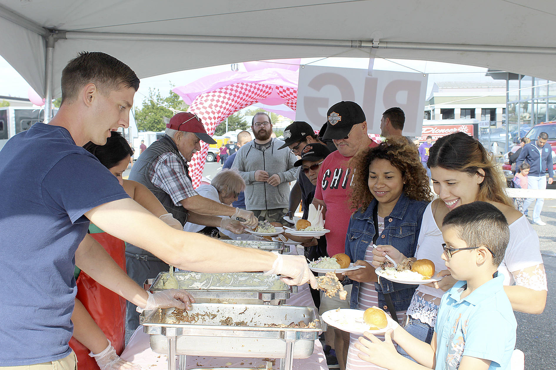 Photo by Patricia Guthrie/Whidbey News-Times                                Volunteers pile up the plates of Diana Benalcazar (wearing jacket) and her relatives at Sunday’s Pigfest. The annual Oak Harbor free buffet raised more than $19,000 for charity.