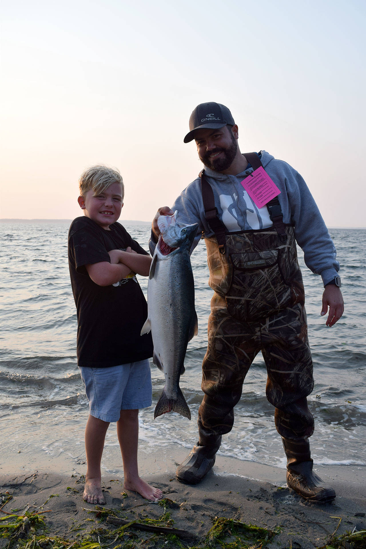 Kyle Jensen / The Record — Beckett Spjute (left) and Alex Spjute (right), visiting from California, hold up Beckett Spjute’s catch. The Spjute family’s friend from Seattle took them fishing at Bush Point Thursday evening.