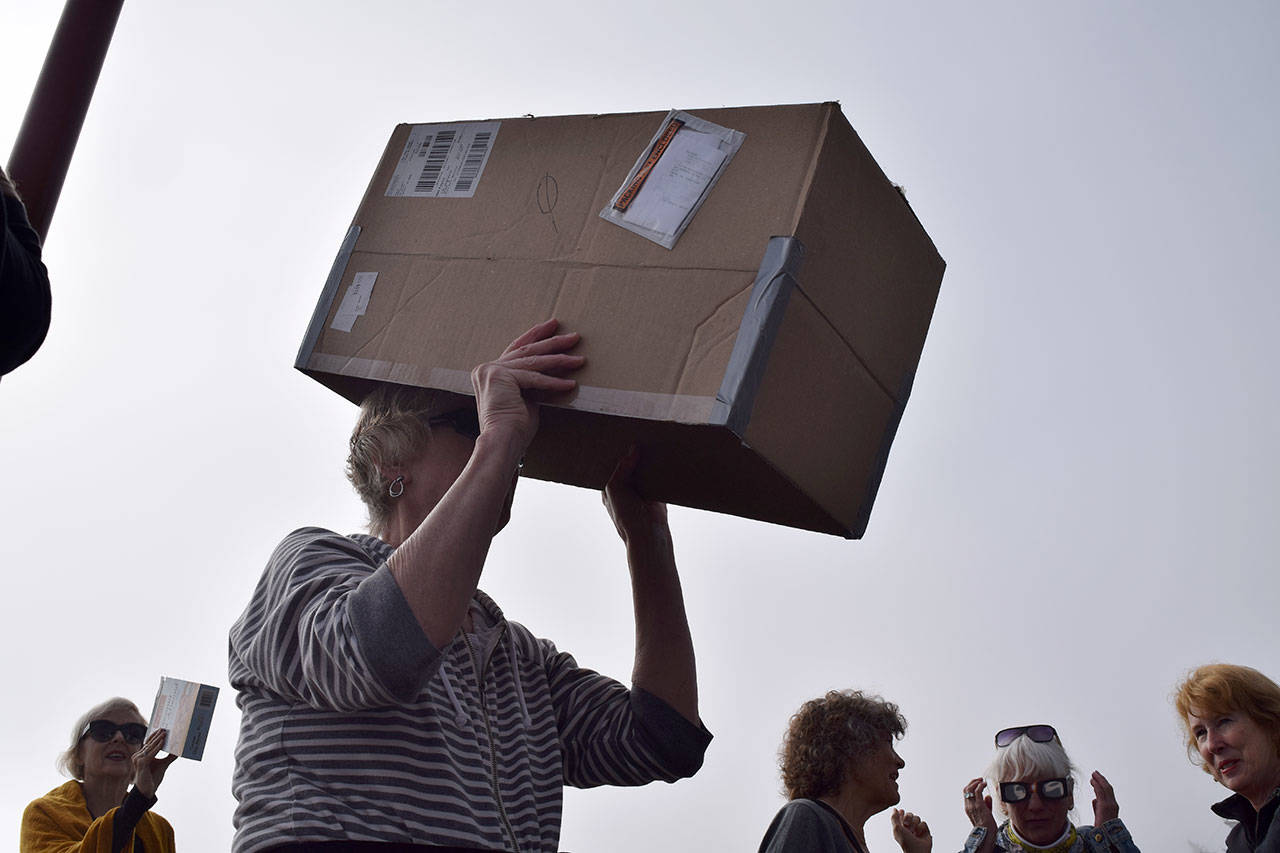 Kyle Jensen / The Record — Langley resident Marcia Wiley uses a pinhole projector made from a cardboard box to see the eclipse without directly looking at the sun.