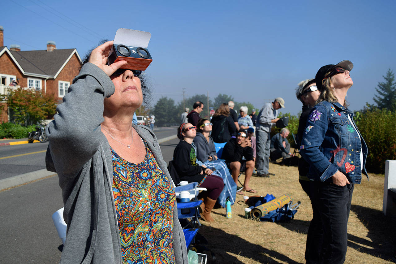 Kyle Jensen / The Record                                Clinton resident Tricia Bozin gazes at the partial solar eclipse alongside others in a crowd on Cascade Avenue.