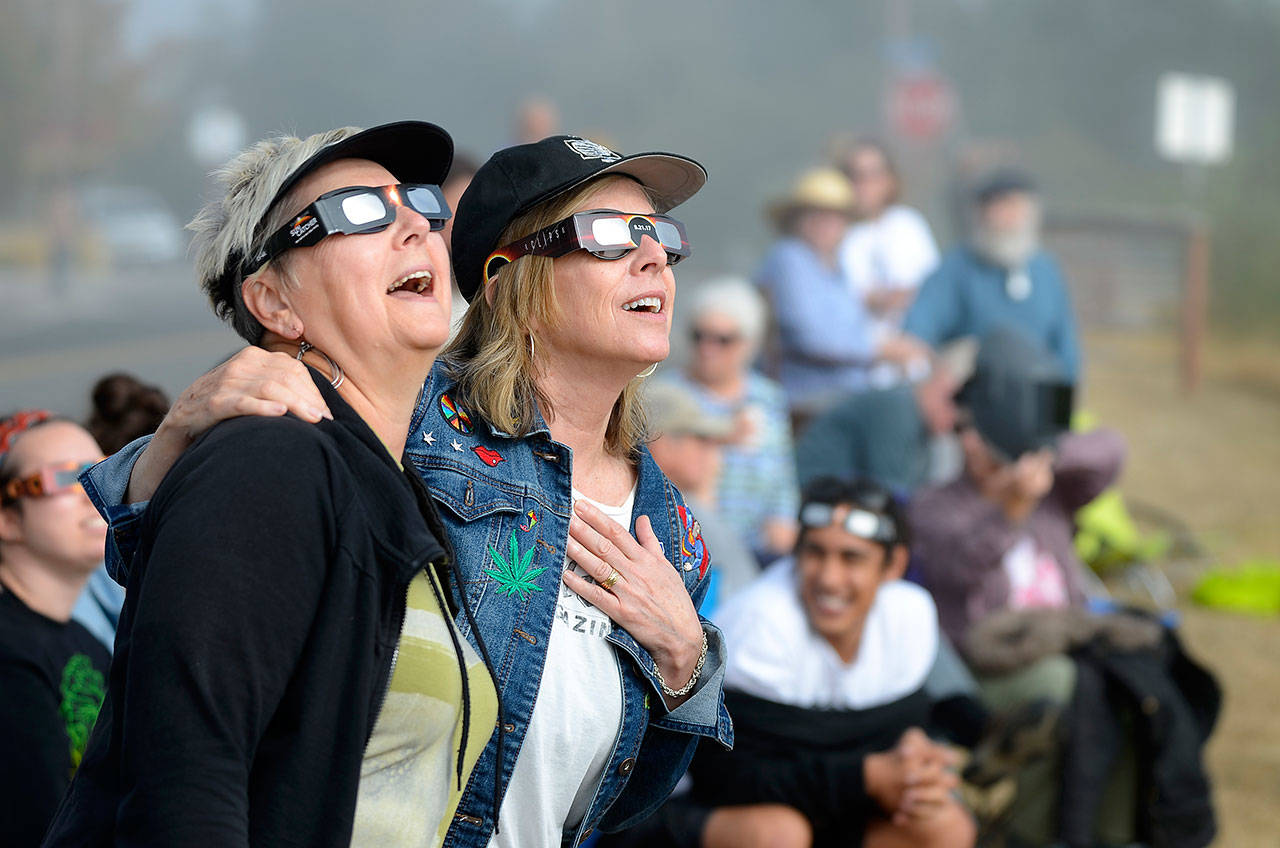 Justin Burnett / The Record — Langley residents Nancy Loorem Adams (left) and Debbie Loudon (right) sing along to Bonnie Tyler’s “Total Eclipse of the Heart” during Monday’s partial solar eclipse.