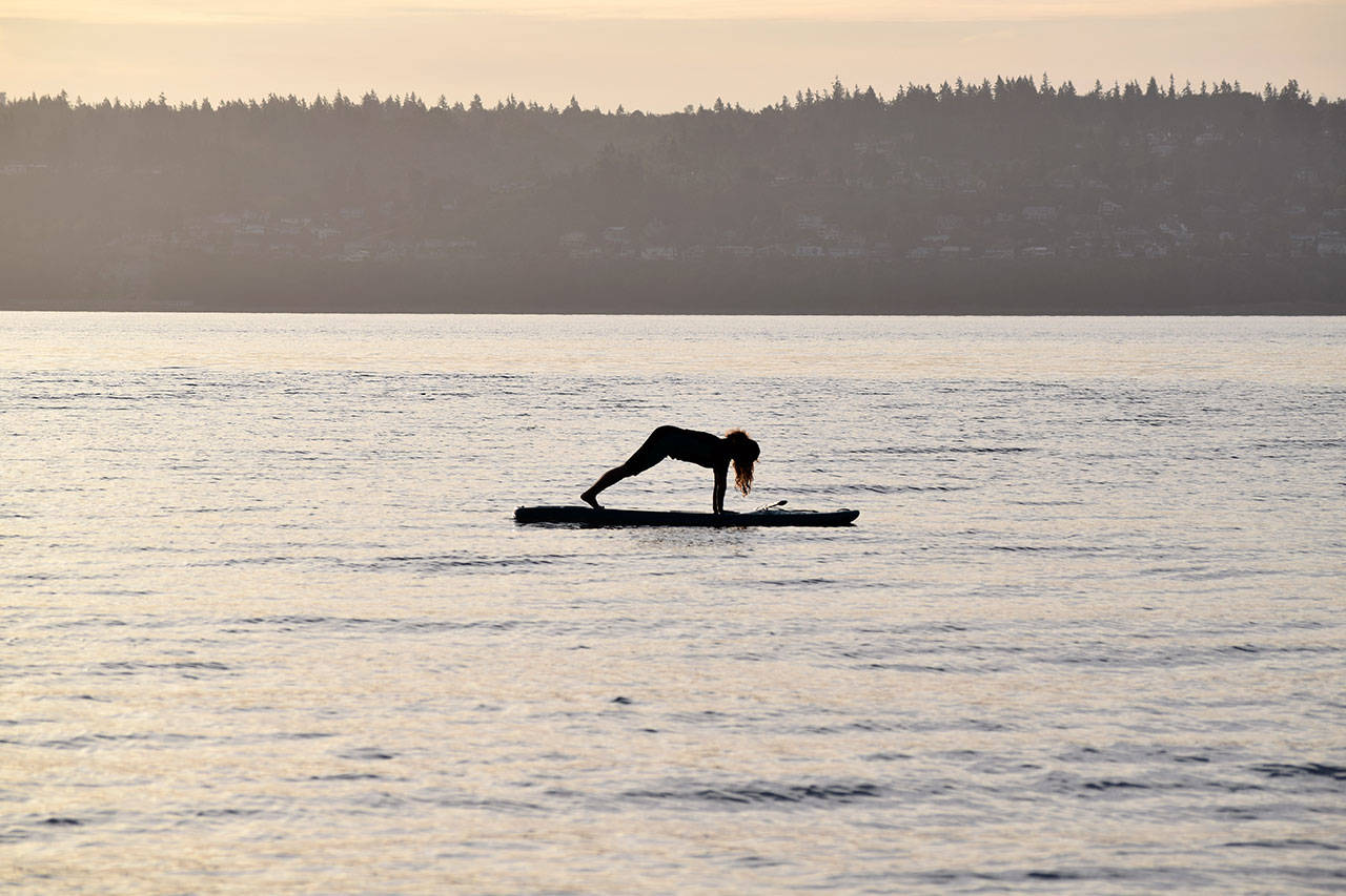 Kyle Jensen / The Record — Aja Stewart, of Clinton, holds a yoga pose on the water during a Friday morning session.