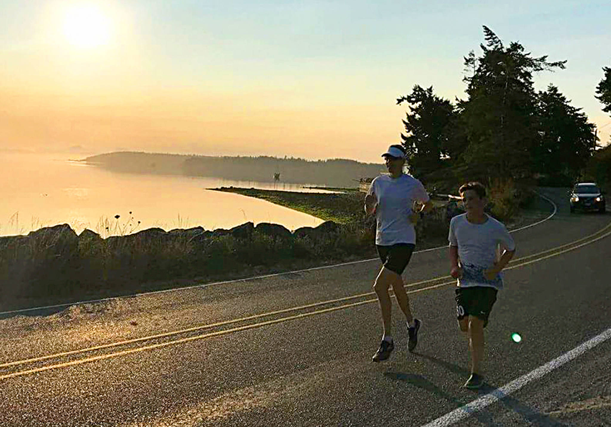 Andy Wyman and Grant Steller run along Madrona Way on the first leg Sunday. Steller was running in place of his father, James Steller, who was ill and couldn’t complete the event he planned. (Submitted photo)