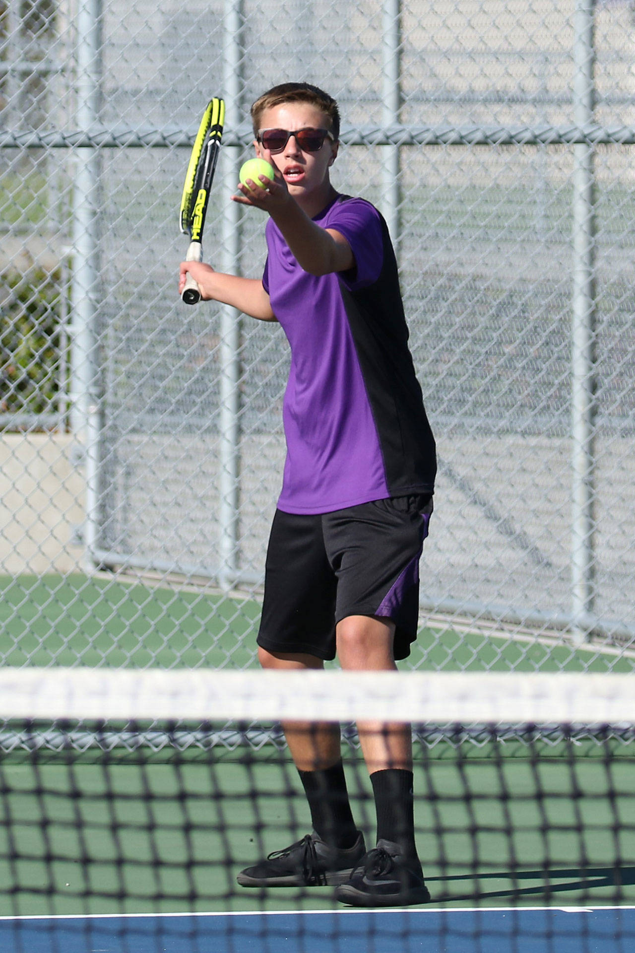 Ridgely Briddell prepares to serve in the second doubles match. (Photo by John Fisken)