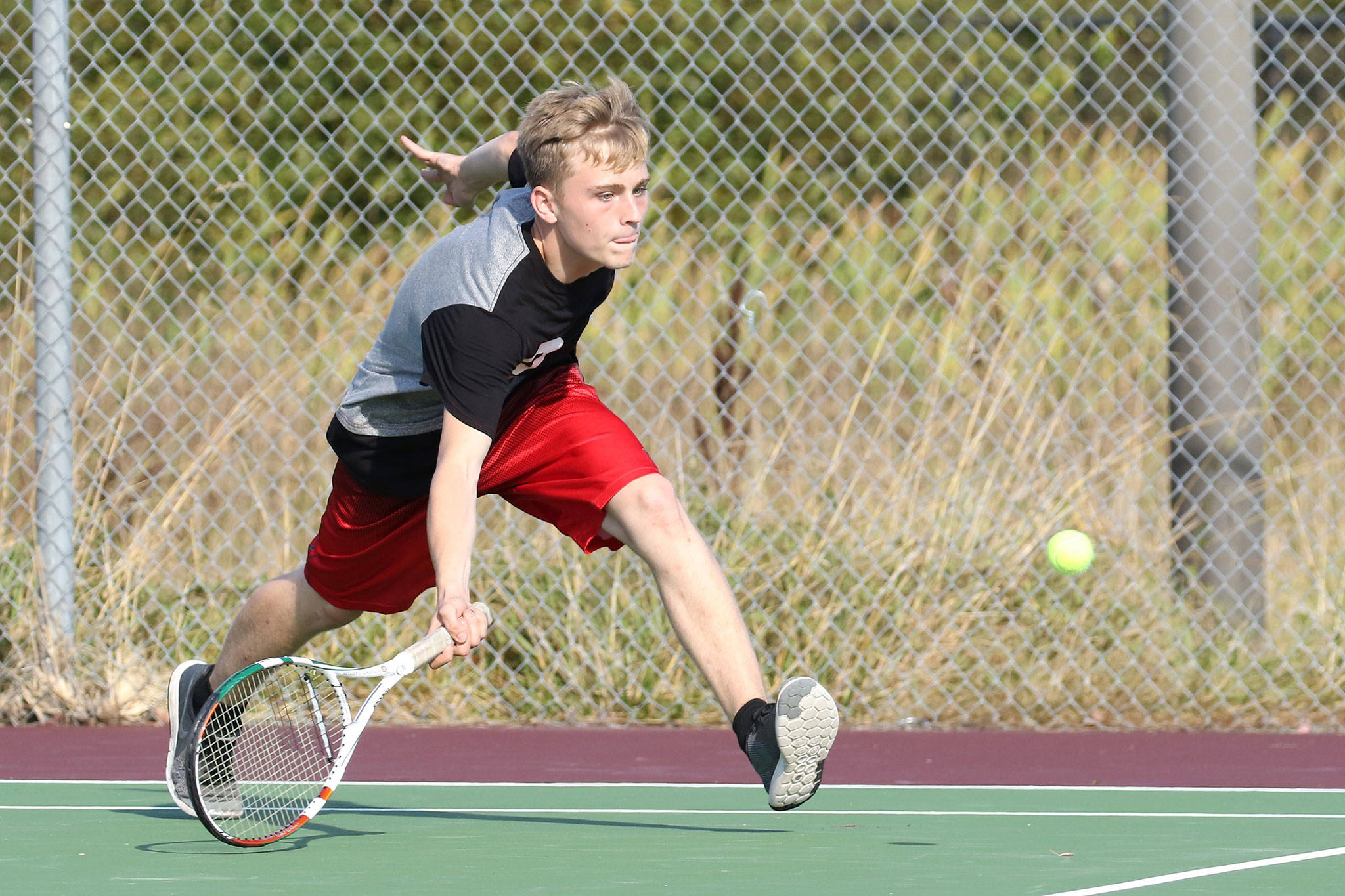 Nile Lockwood races in for a shot in his win in third singles. (Photo by John Fisken)