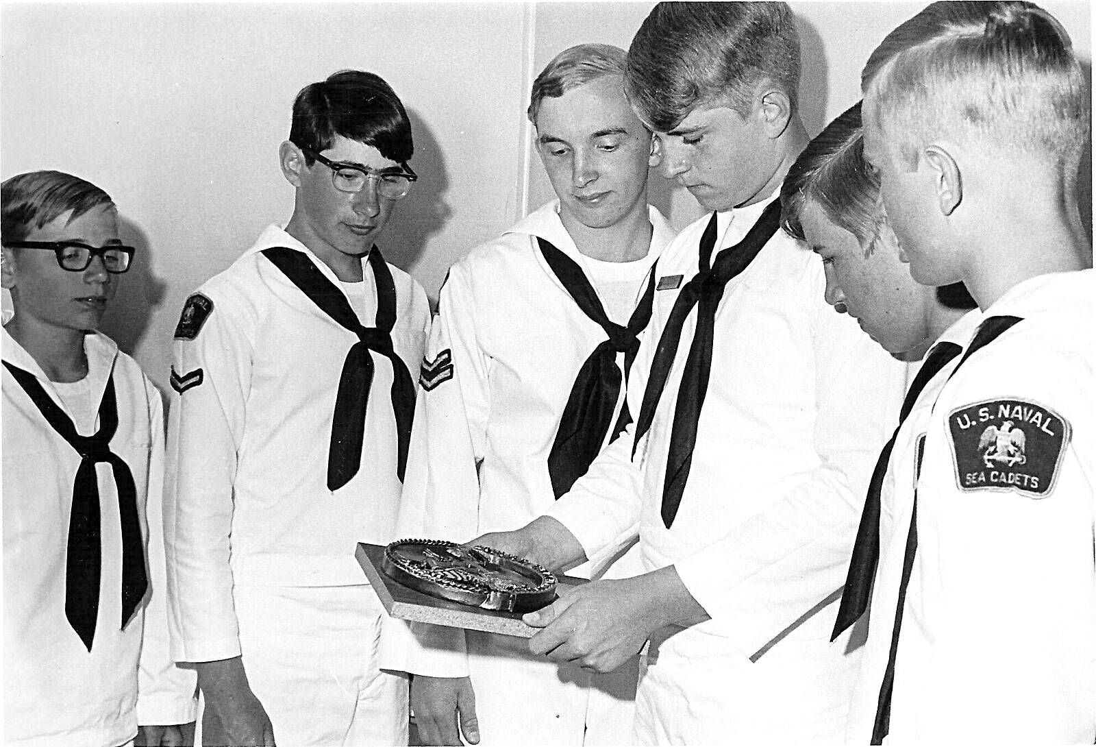 Sea cadets in the 1970s admire a trophy.