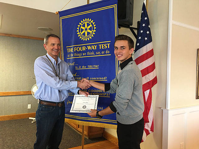 Rotary club president Steve Powers presents Jordan George with a certificate.