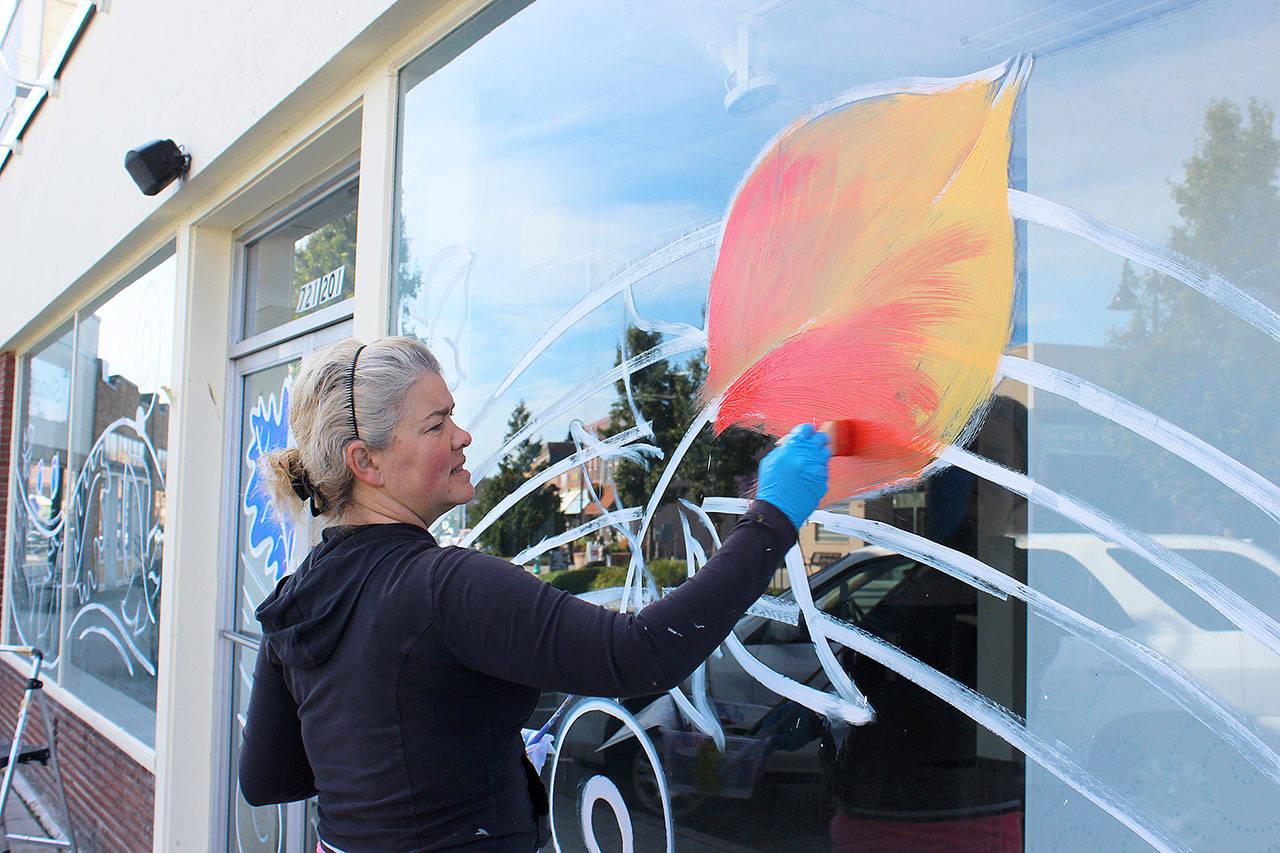 Stephanie Fries transforms Pioneer Way shop windows into swirling images of fall colors. She used some of the design she’d previously created for the Oak Harbor Music Festival. Photos by Patricia Guthrie/Whidbey News-Times