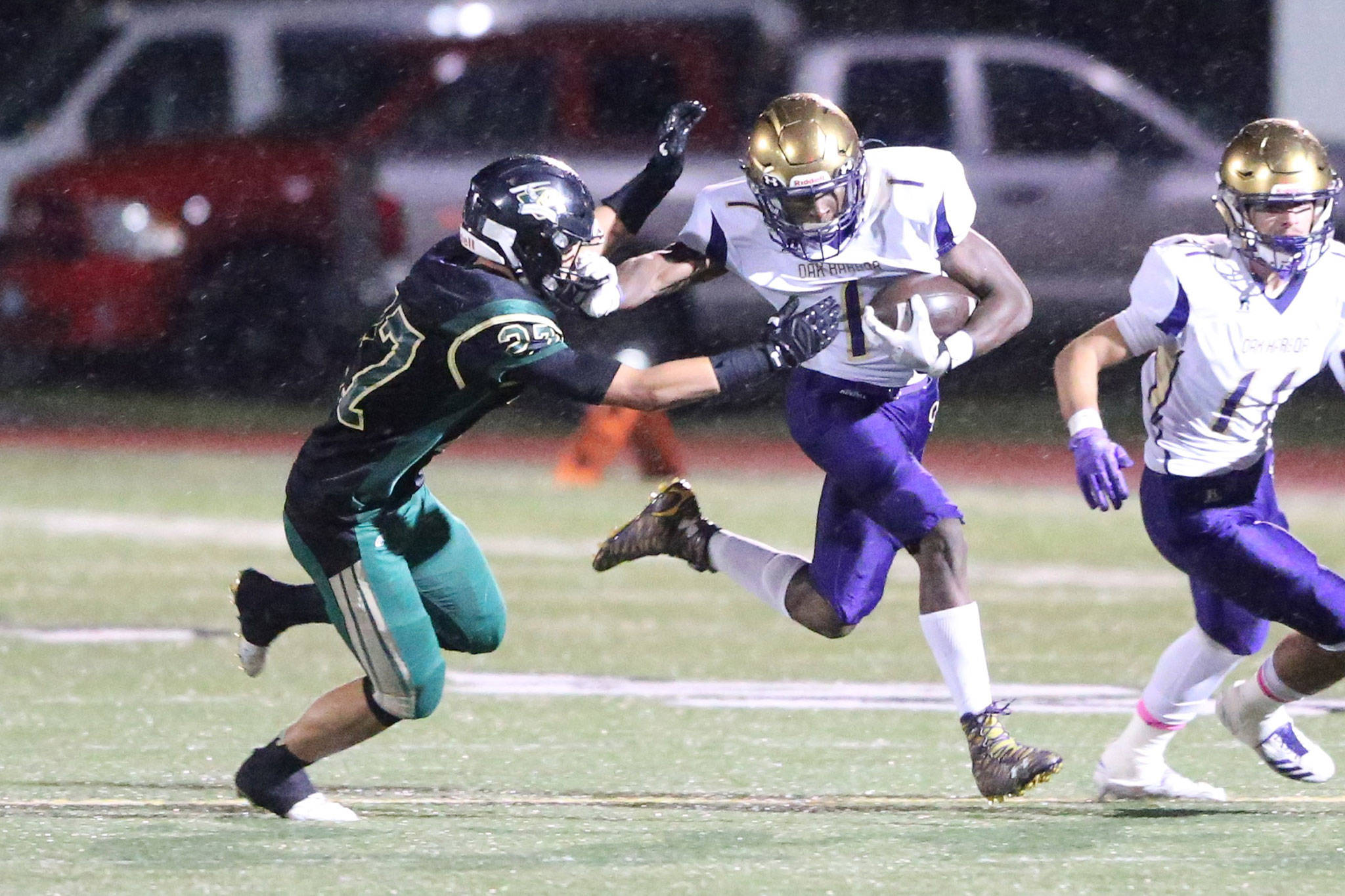 Oak Harbor&rsquo;s Taeson Hardin pushes past the Chargers&rsquo; Dylin Rice as Kyle Nickols (11) looks for a man to block. Hardin rushed for 184 yards and two touchdowns for the Wildcats in Friday&rsquo;s game. (Photo by John Fisken)