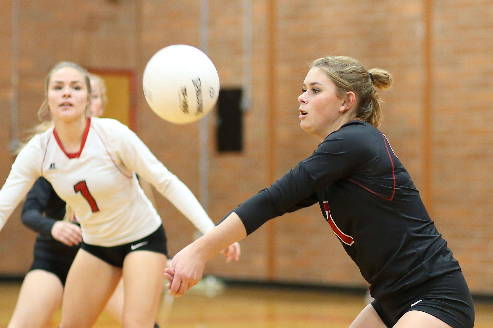 Payton Aparicio, right, Hope Lodell (1), Allison Wenzel (behind Lodell) and the rest of the Coupeville volleyball team play at the district tournament this weekend in hopes a securing a berth in the state tournament. (Photo by John Fisken)