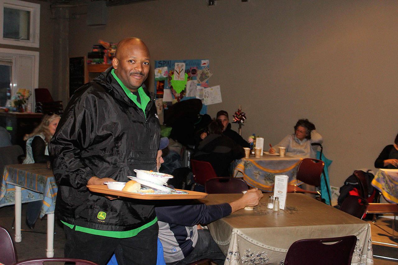 Pastor Sam Giles of Living Faith Christian Center helps clear the dinner his congregation cooked and served as part of its community outreach.