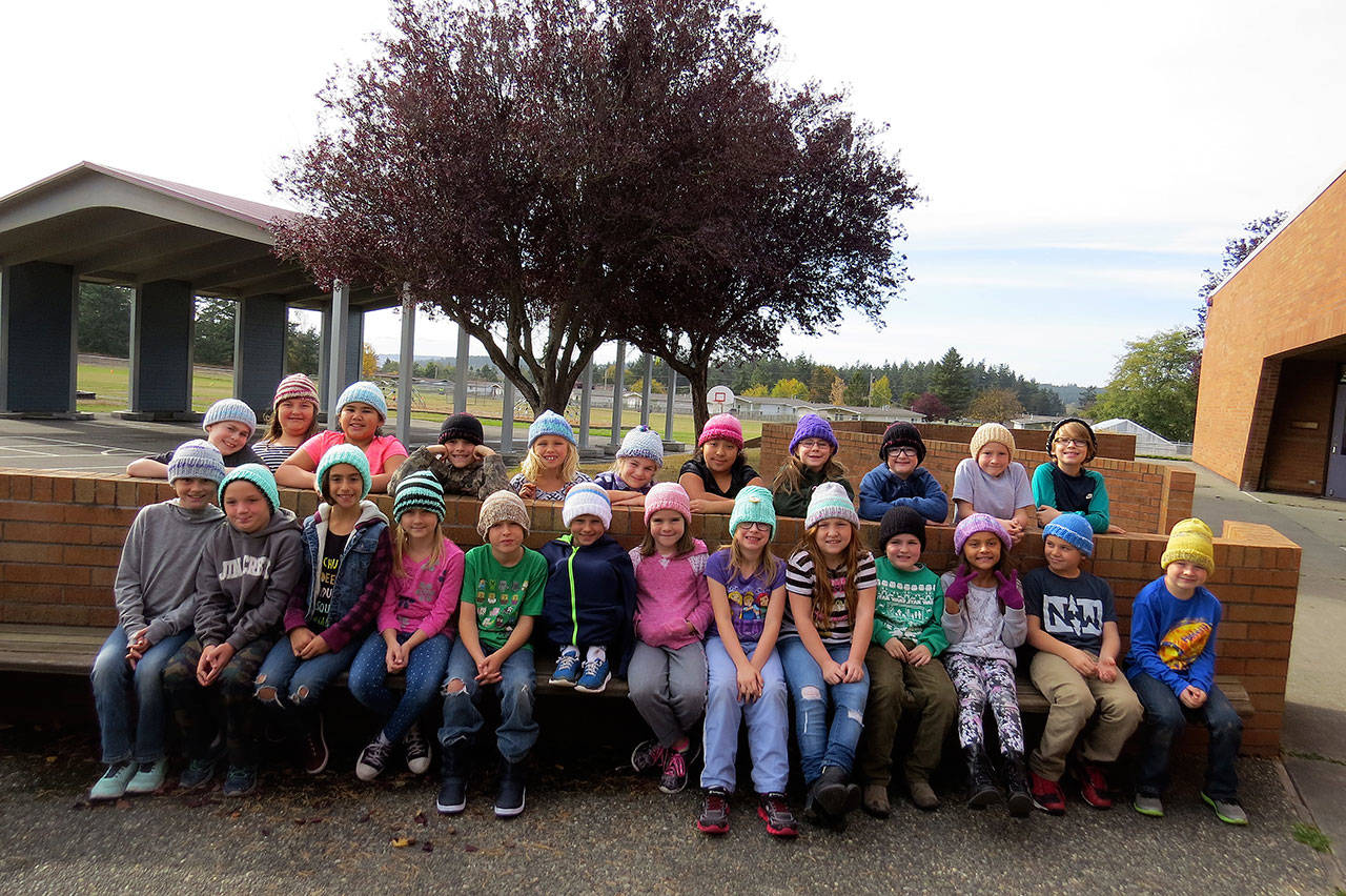 Rebecca Ching’s third-grade class pose with their new hats, handmade by Oak Harbor’s Dorothy Bell. Photo provided by Rebecca Ching