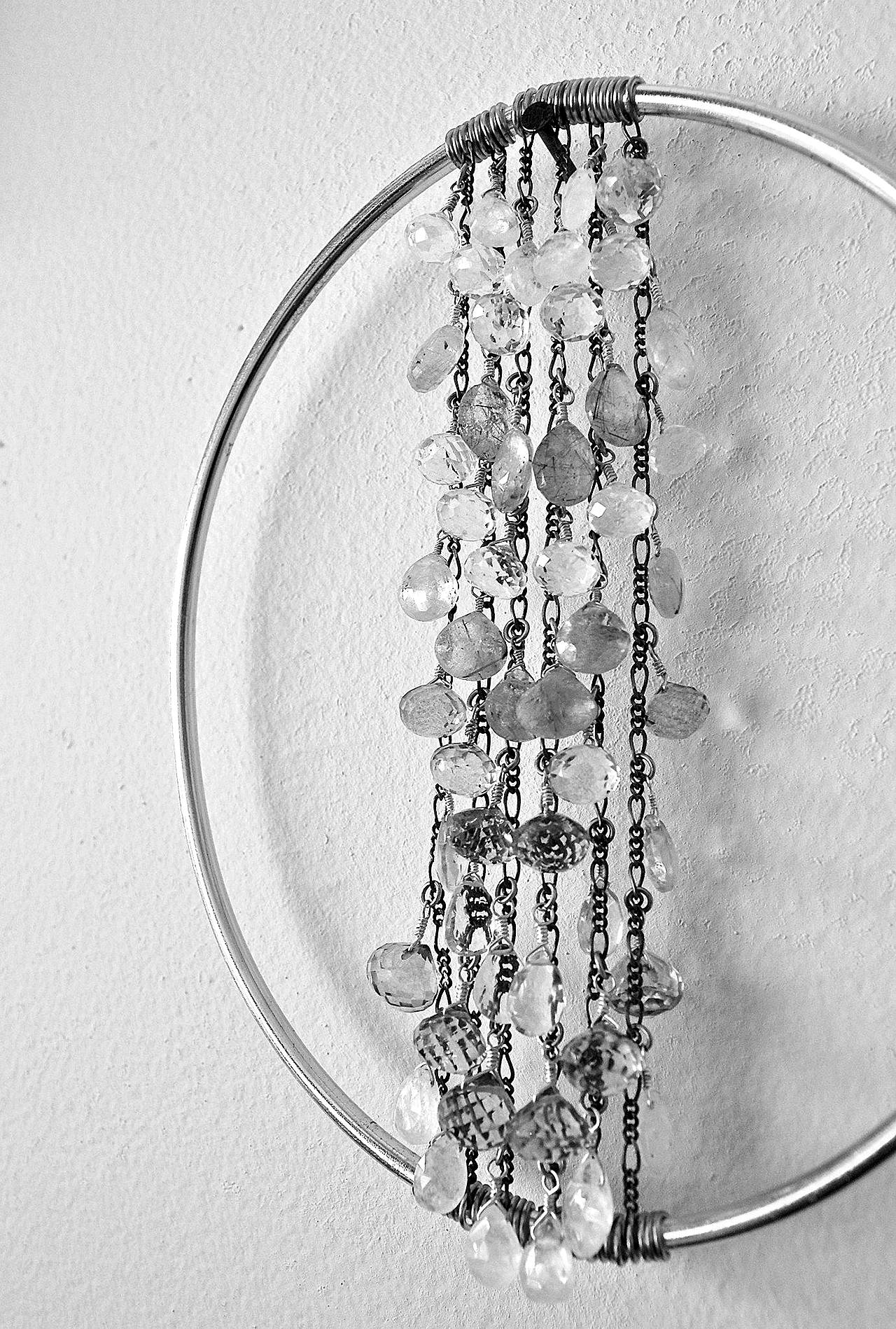 Alexa Allamano photo                                Allamano makes home decor in addition to jewelry. In this piece, 52 gemstones are tethered to vertical chains and suspended in the center of a brass oval.