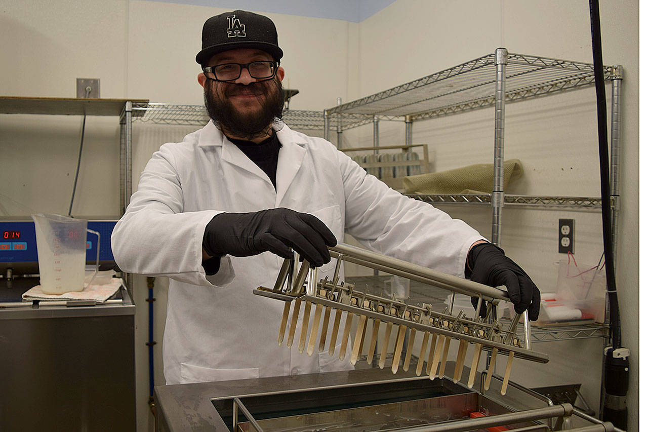 Kyle Jensen / The Record — Whidbey Island Ice Cream employee Joe Valencia prepares to put sticks in the company’s ice cream bars before they freeze.