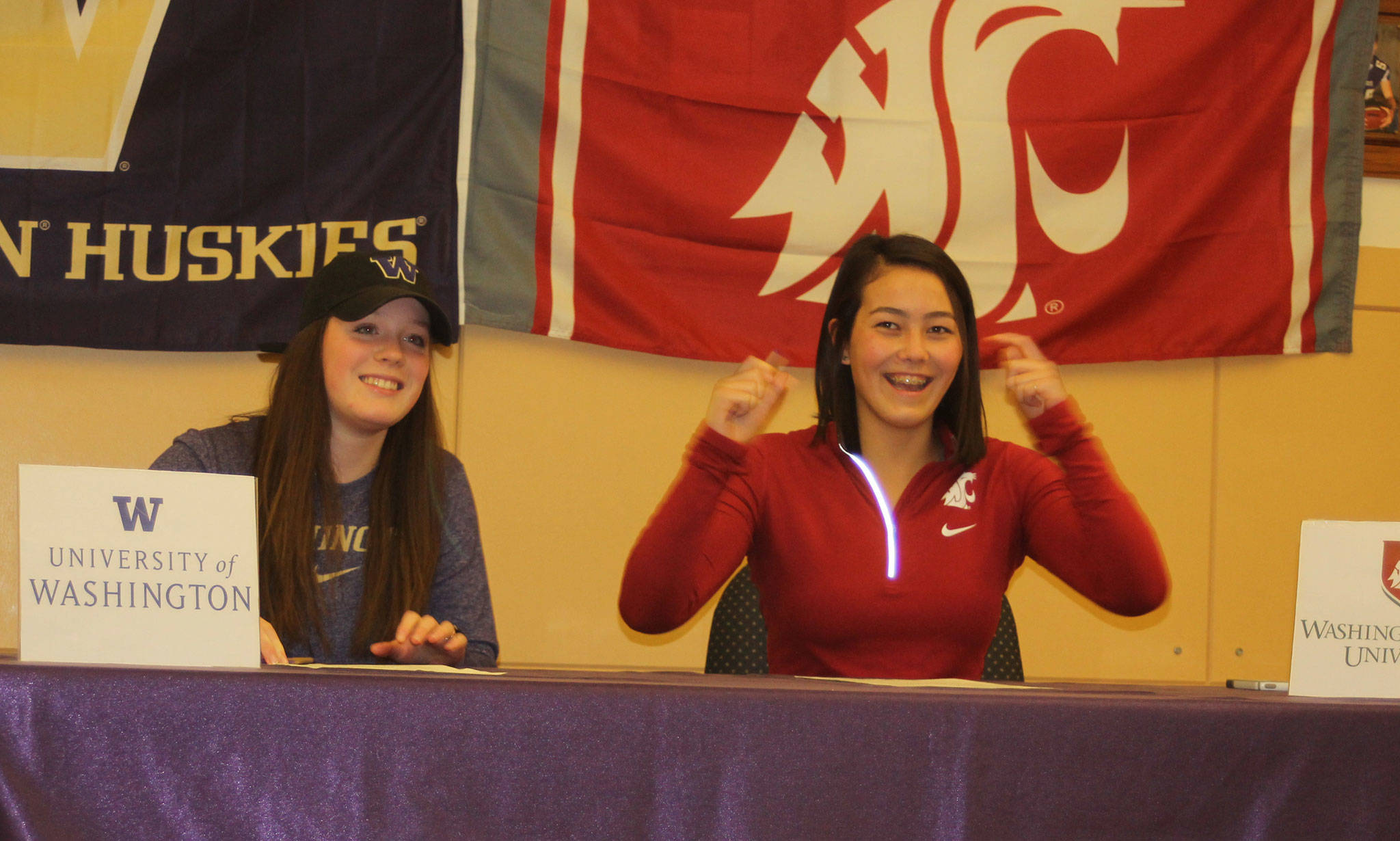 Olivia Tungate, right, celebrates after signing a letter of intent to swim for Washington State University. Jillian Pape, left, will row for the University of Washington. (Photo by Jim Waller/Whidbey News-Times)