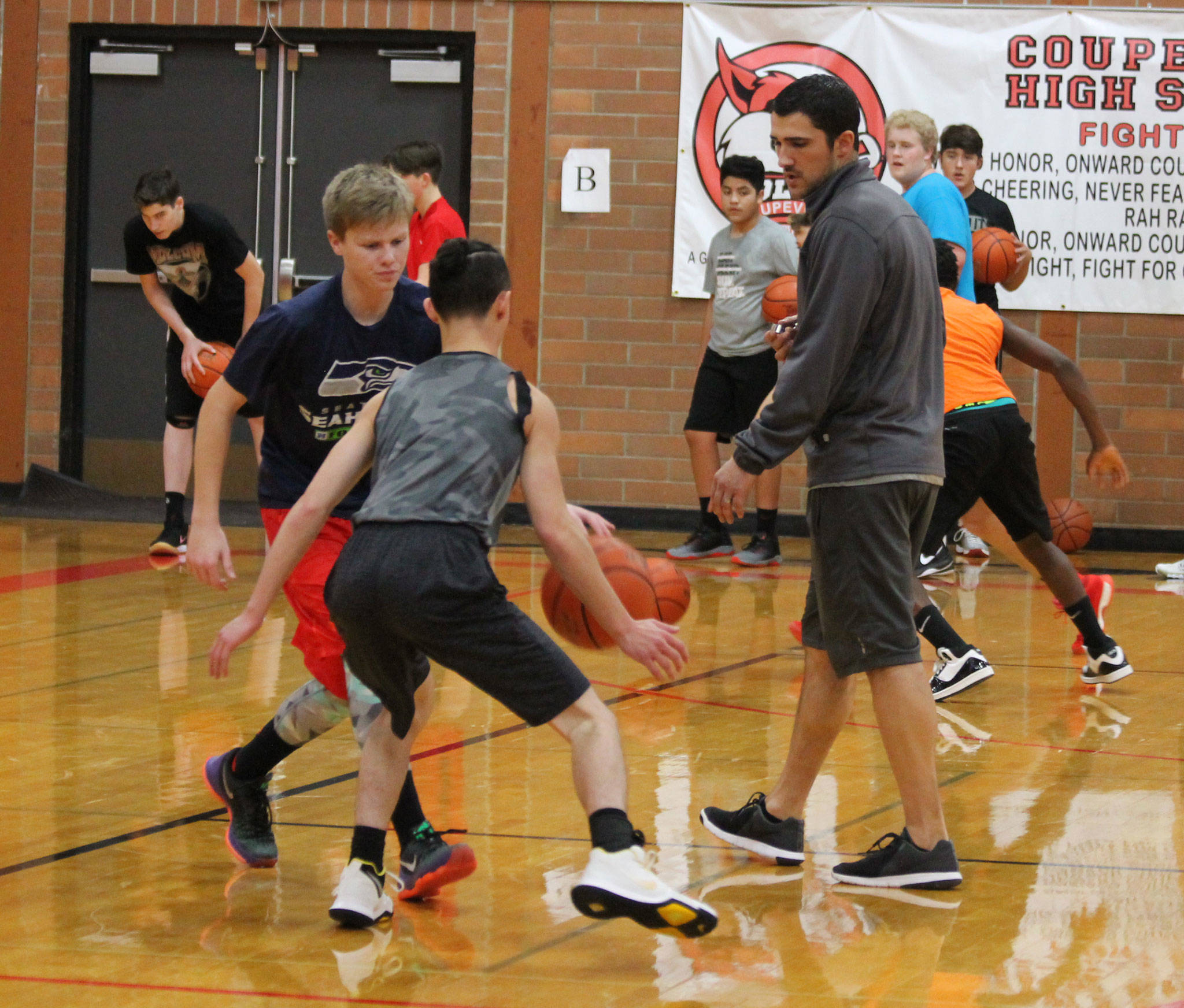 New Coupeville High School boys basketball coach Brad Sherman watches Mason Grove, left, and Jered Brown work during a drill Thursday. (Photo by Jim Waller/Whidbey News-Times)