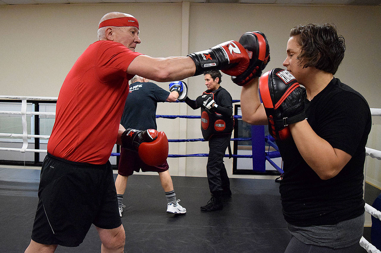 Kyle Jensen / The Record — Clinton resident Steve Burr works with trainer Lauren Coleman on the punch mitts.