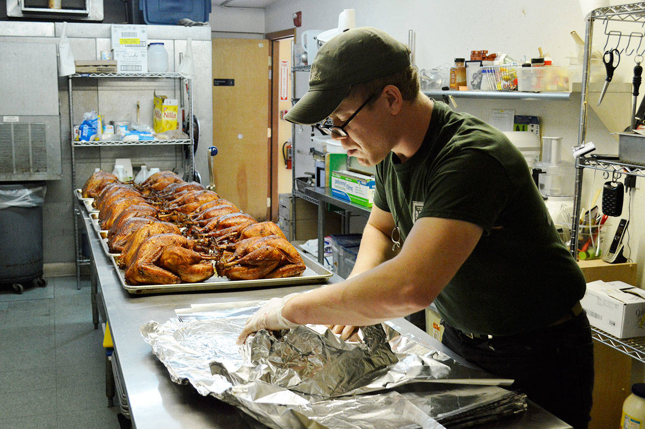 Earren Henley, from The BBQ Joint, prepares to wrap up the 40 turkeys smoked for the free Thanksgiving Dinner put on by North Whidbey Community Harvest. Photo by Laura Guido/Whidbey News-Times