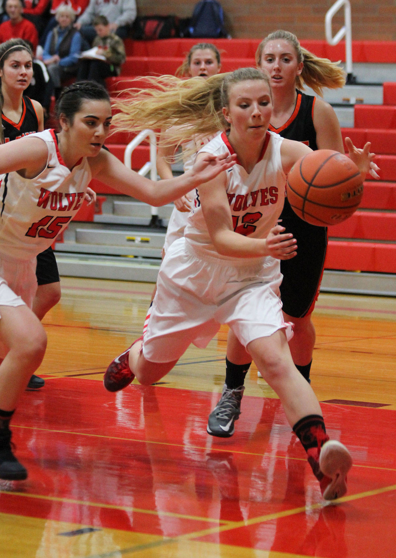 Allison Wenzel (12) chases down a loose ball ahead of teammate Kalia Littlejohn.(Photo by Jim Waller/Whidbey News-Times)