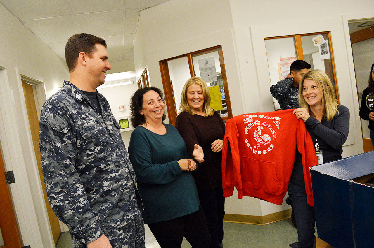 From the left, Petty Officer First Class Rob Stuart, Tiffany Wheeler-Thompson, Joanne Pelant and Carolyn Pence look at some of the clothes Stuart donated after running a drive with his squadron, VAQ-129. Stuart collected nearly 600 pieces of clothing for the Housing Support Center. Photo by Laura Guido/Whidbey News-Times