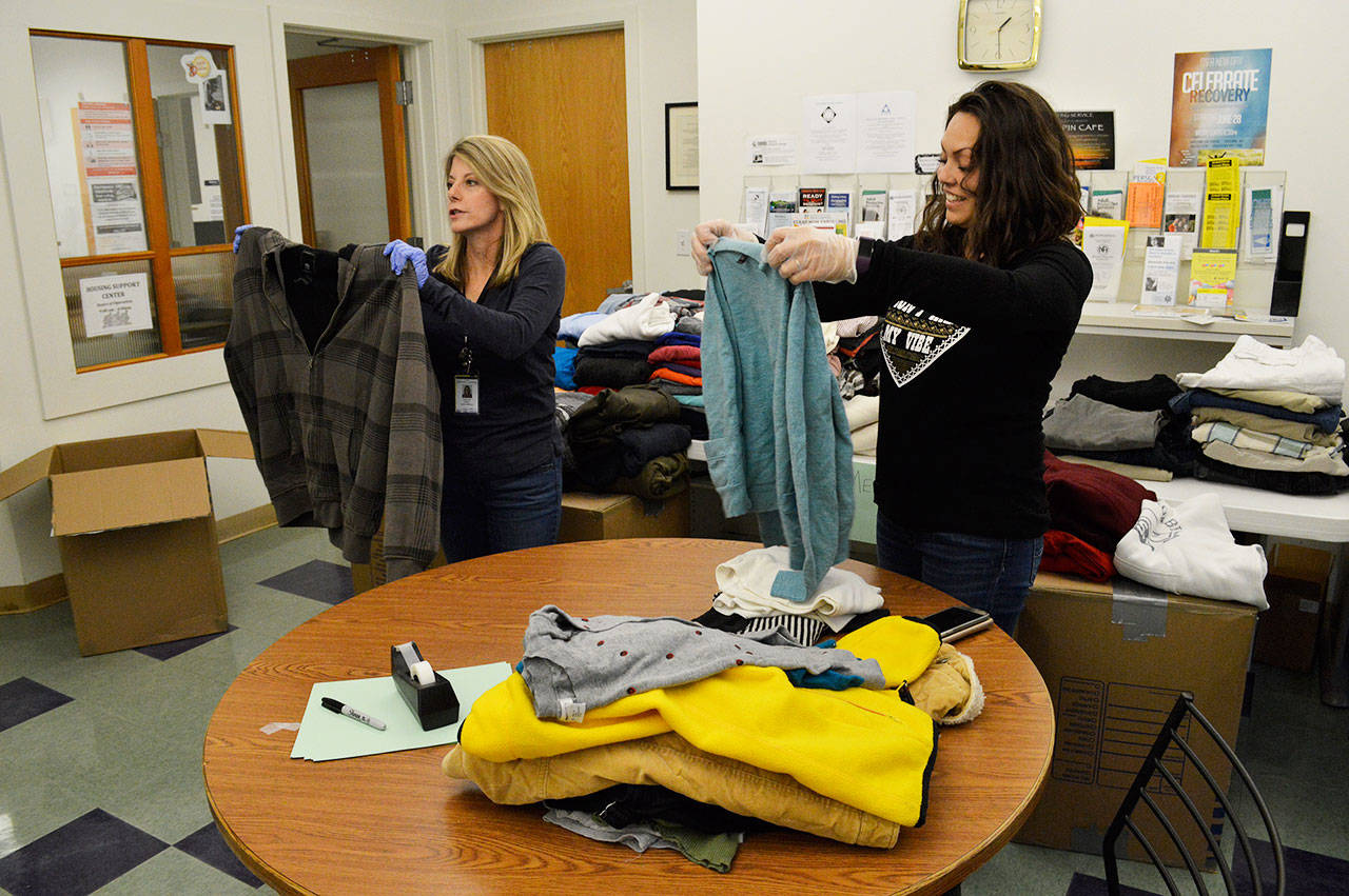 Carolyn Pence, left, and Malissa Taylor fold clothes donated by Petty Officer First Class Rob Stuart from VAQ-129. Stuart’s drive also inspired a seaman in his squadron to run a toiletry drive for the Housing Support Center as well. Photo by Laura Guido/Whidbey News-Times