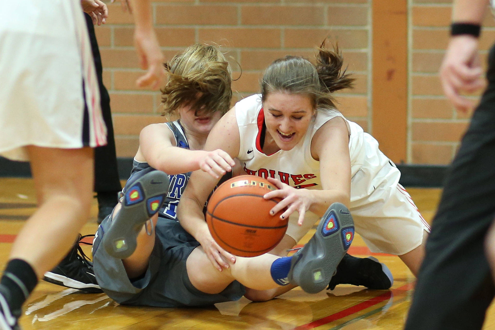 Coupeville’s Mikayla Elfrank dives over Mount Vernon Christian’s Josie Droog to corral a loose ball. (Photo by John Fisken)