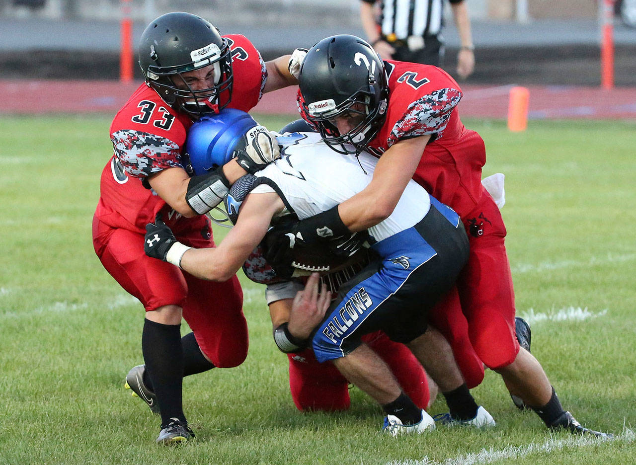 Coupeville tacklers smother a South Whidbey ball carrier in a non-league game in 2016. The Wolves could be joining their island rivals in a new confernce next year. (Photo by John Fisken)