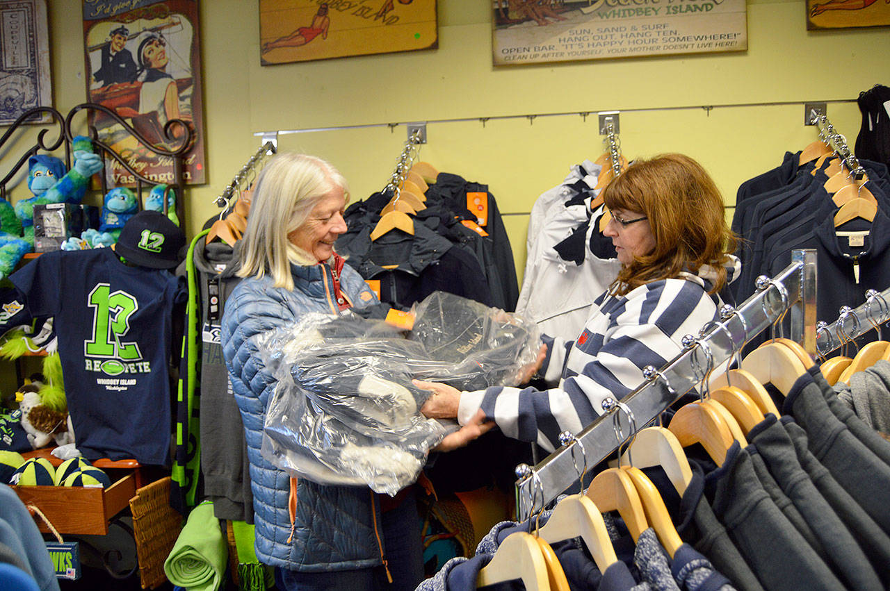 Patti Brigman, right, and Vickie Chambers, left, collect items from Brigman’s Coupeville shop Back to the Island to donate for the Coupeville Community Care Team’s annual drive. Photo by Megan Hansen/Whidbey News Group