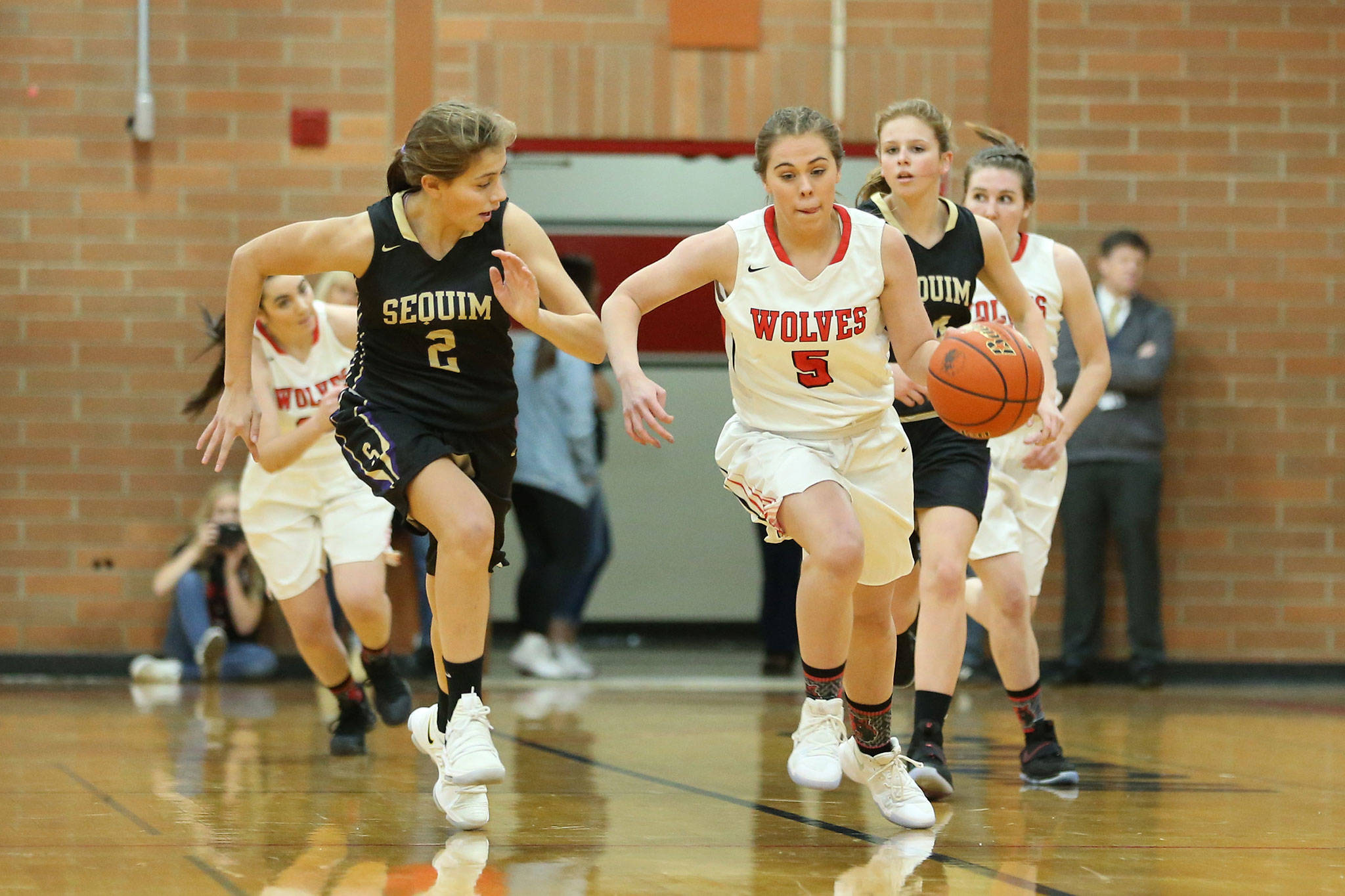 Coupeville’s Kyla Briscoe takes off on a fast break as Sequim’s Jessica Dietzman (2) tries to keep up. (Photo by John Fisken)