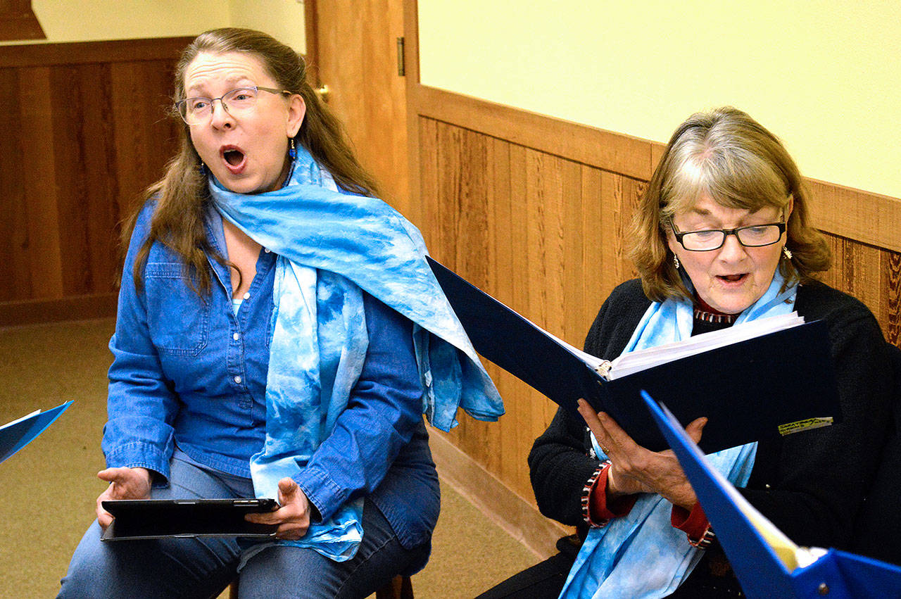 Photo by Laura Guido/Whidbey News-Times                                Dinah Majure and Ginny Vracin, members of the Saratoga Sirens, practice for the Coupeville Caroling Contest. Six teams representing local nonprofit organizations will be placed around downtown starting at 1 p.m. today.