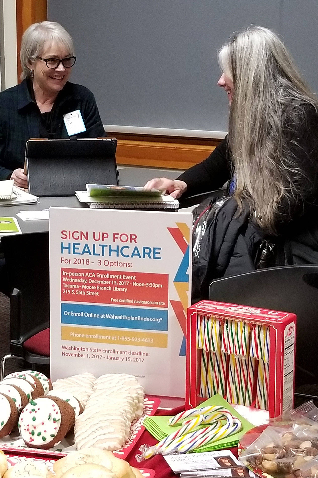 Opportunity Council navigator Lisa Clark (left) talks about healthcare enrollment in Freeland last month. The same free service is scheduled Tuesday, Jan. 9, 1-7 p.m. at Skagit Valley College in Oak Harbor. Photo provided
