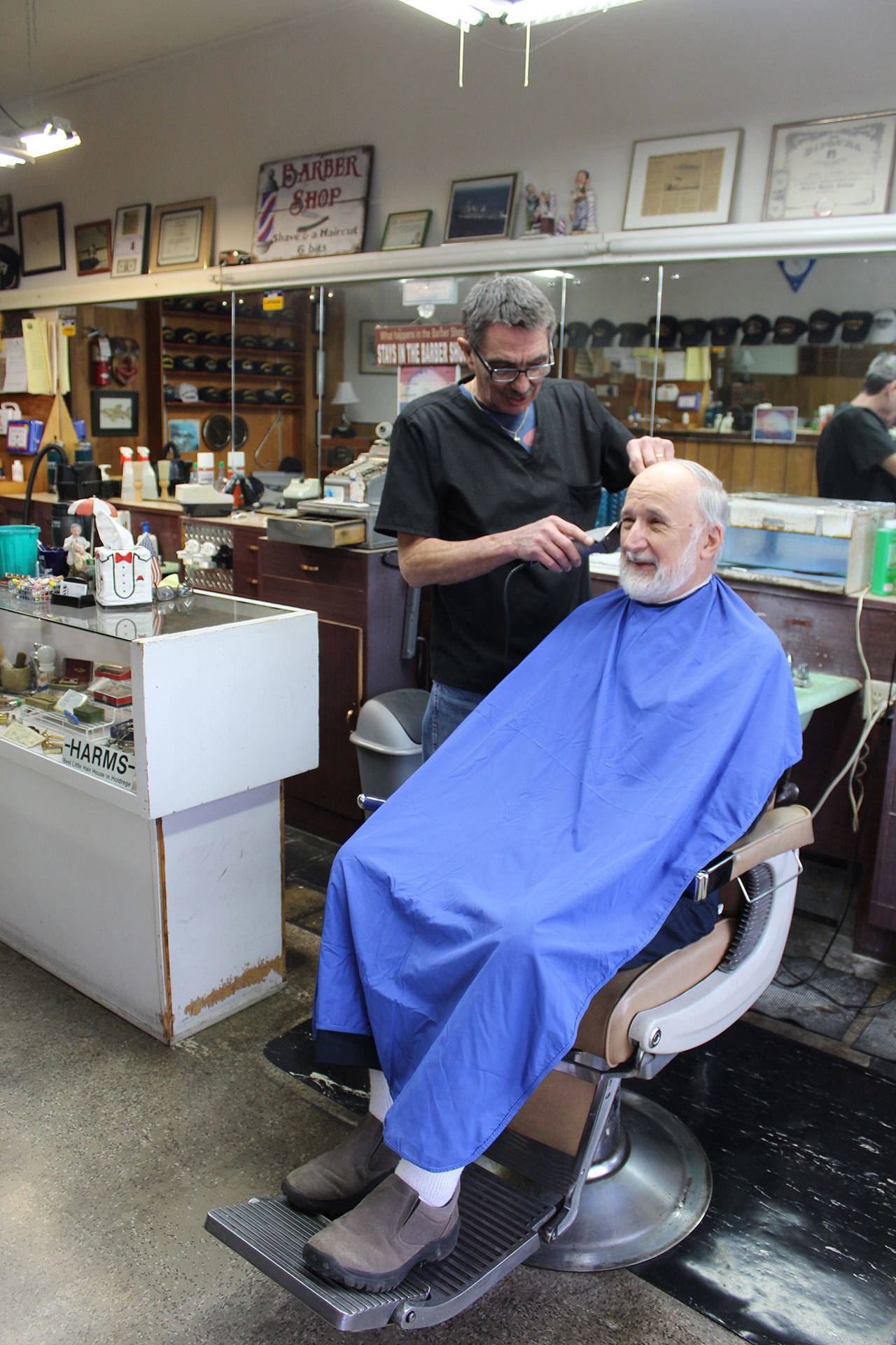 Wanting “a little off the top” customer Bo Chernikoff sits down for a trim at Midway Barber Shop in Oak Harbor. Owner Dave Cleary recently returned after undergoing brain surgery for a cyst that affected his vision. Photo by Patricia Guthrie/Whidbey News-Times