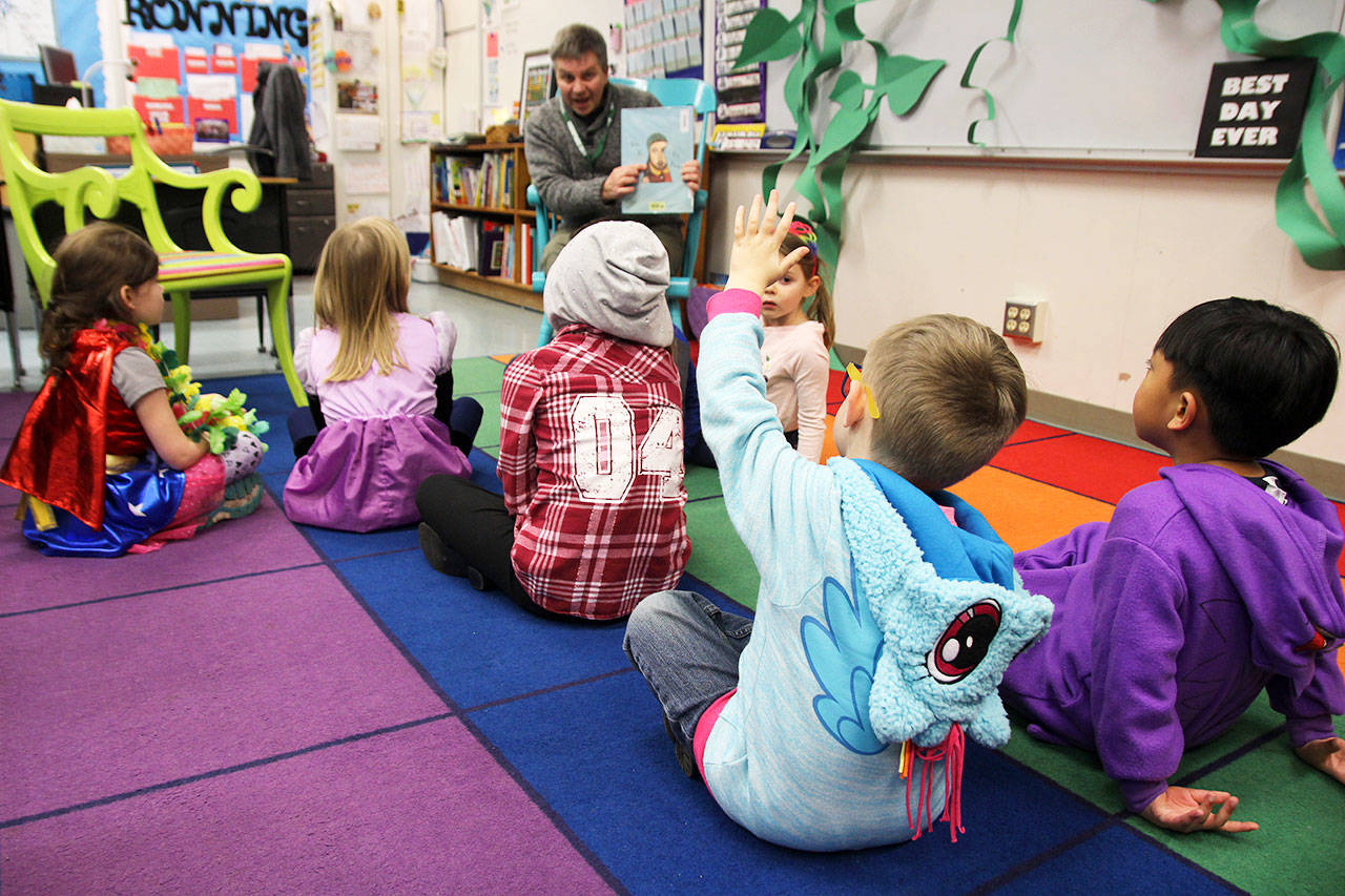 Ashton Drake raises his hand while Rob Flack reads Kate and the Beanstalk Thursday at Broad View Elementarys Literacy Night. The reading of the fractured fairy tale was part of an event to promote literacy and family engagement. Photo by Laura Guido/Whidbey News-Times