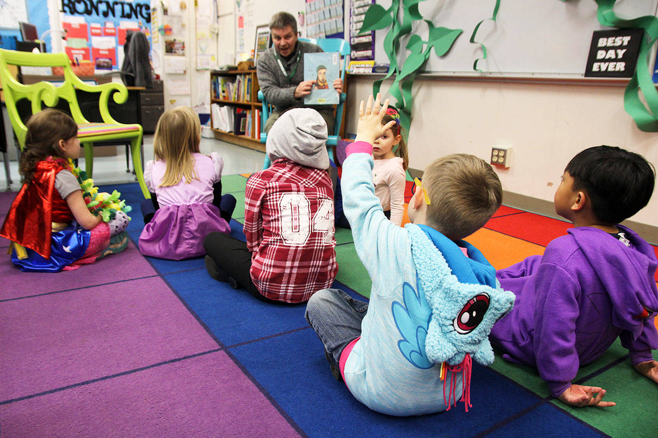 Ashton Drake raises his hand while Rob Flack reads “Kate and the Beanstalk” Thursday at Broad View Elementary’s Literacy Night. The reading of the “fractured fairy tale” was part of an event to promote literacy and family engagement. Photo by Laura Guido/Whidbey News-Times
