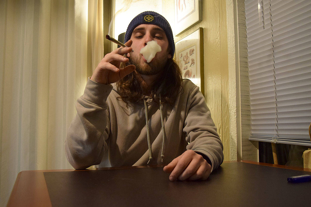 Evan Thompson / The Record — Langley resident Steven Sutton smokes a joint on his day off from work Monday night. Sutton, who is a bud tender at Whidbey Island Cannabis Company in Freeland, isn’t worried about the federal government’s promise to heavily enforce marijuana laws.