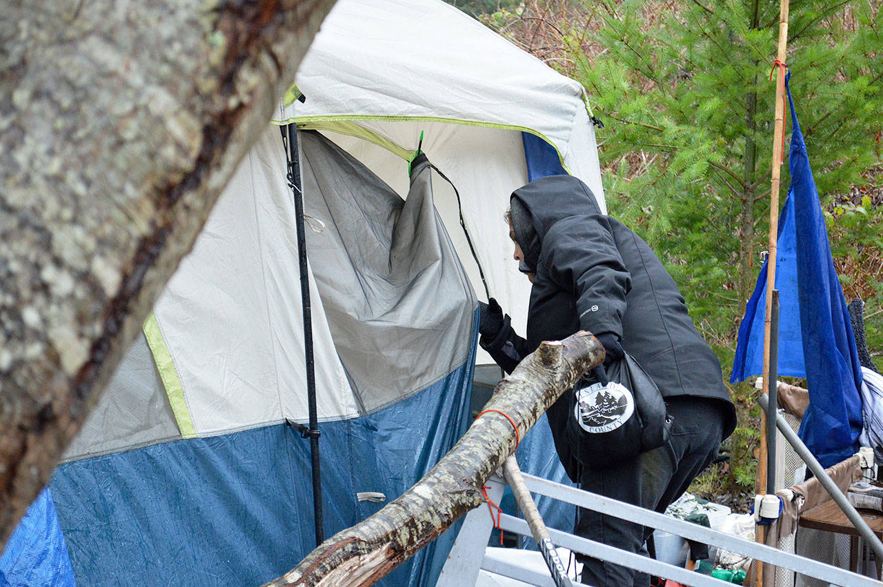 Ida Armendariz, a volunteer in the Point in Time Count, searches a homeless camp. The annual count aims to survey as many homeless individuals in the county as possible. Photo by Laura Guido/Whidbey News-Times