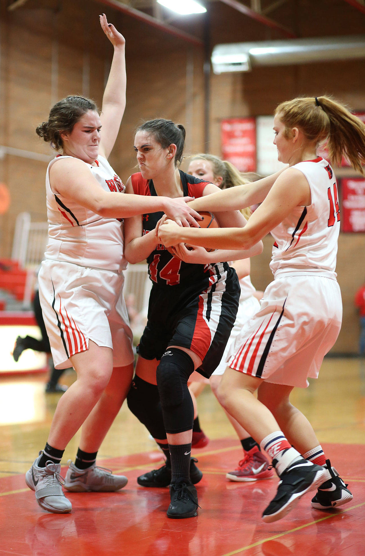 Coupeville’s Sarah Wright, left, and Ema Smith put the clamps on Port Townsend’s Izzy Hammett.(Photo by John Fisken)