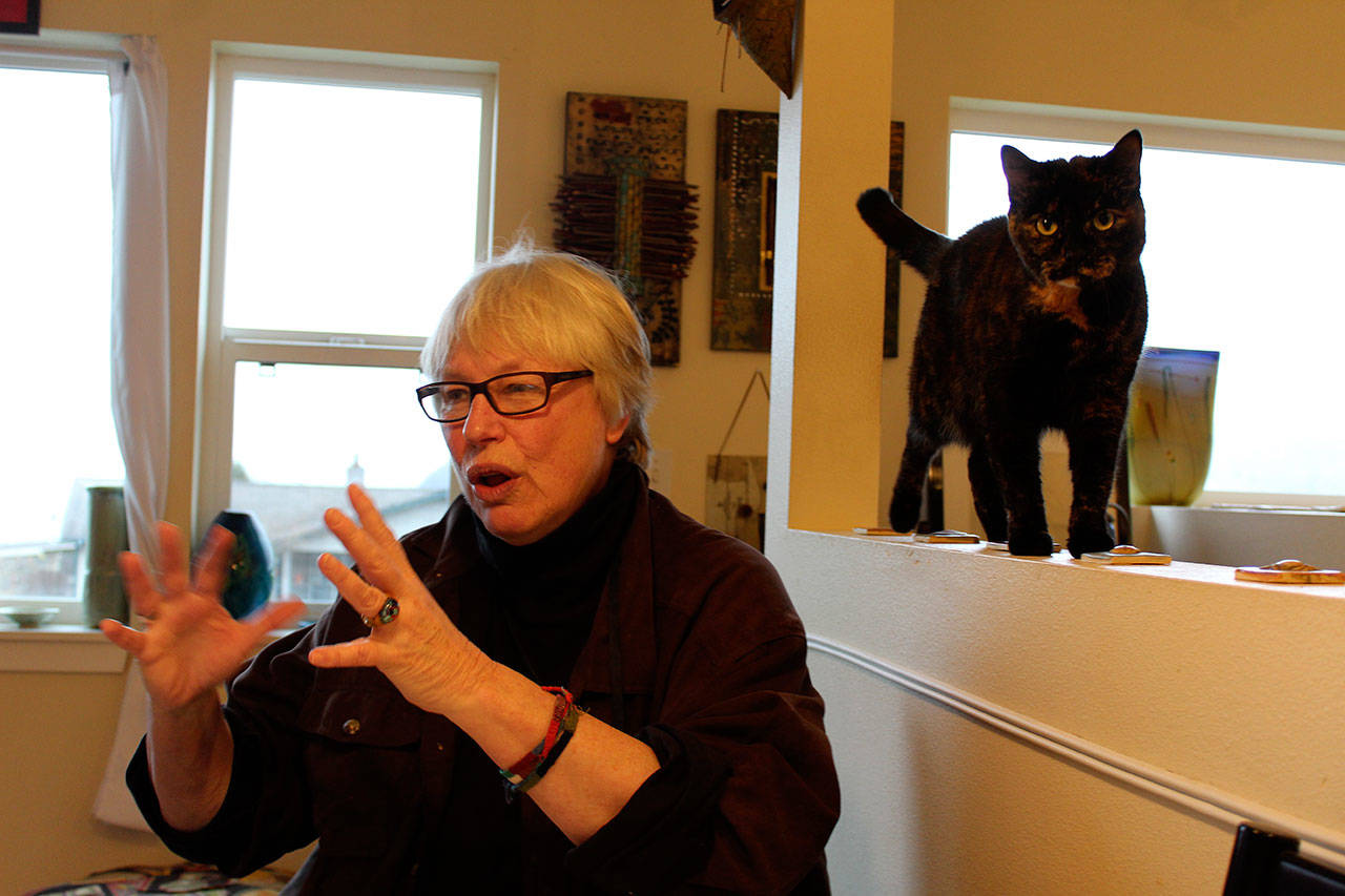 Susan Jensen at home with with cat, Maggie. Well-known on Whidbey for her pet caricatures, Jensen recently wrote two childrens books dealing with the weighty issues of alcoholism and global warming. Photo by Patricia Guthrie/Whidbey News-Times