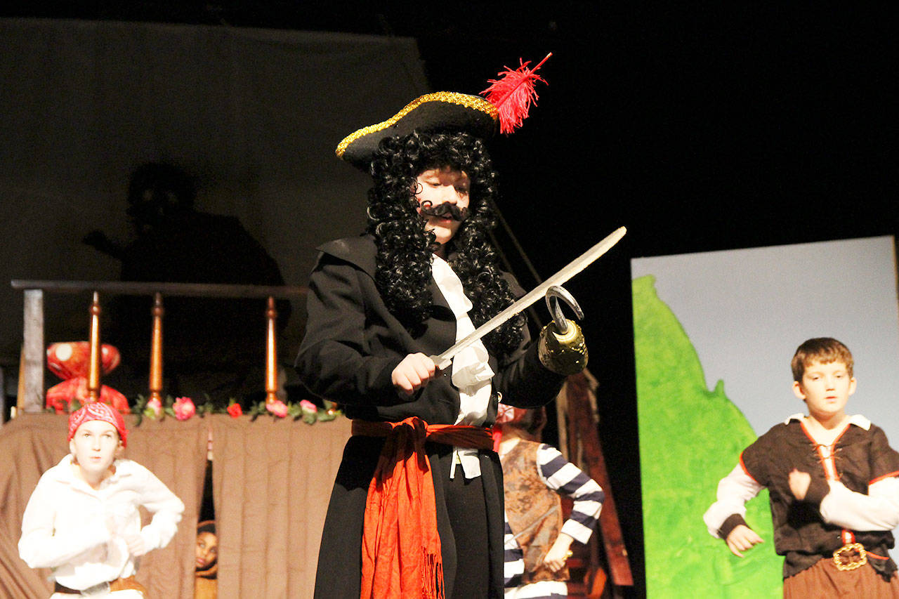 Nicholas Wasik, as Captain Hook, sharpens his sword, while supported by pirates Yhomas Streliw, back left, and Mason Butler. The Coupeville Elementary School Drama Club rehearsed Monday evening for a show to the school on Friday and for the community at noon on Saturday. Photo by Laura Guido/Whidbey News-Times