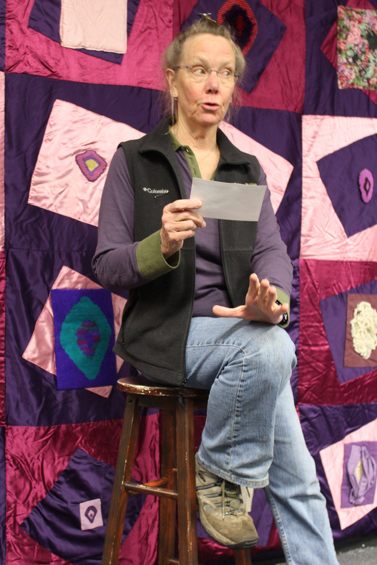 Diane Leganza reads from “The Vagina Monologues” in front of the vagina quilt she made for a college art project. Photo by Patricia Guthrie/Whidbey News-Times