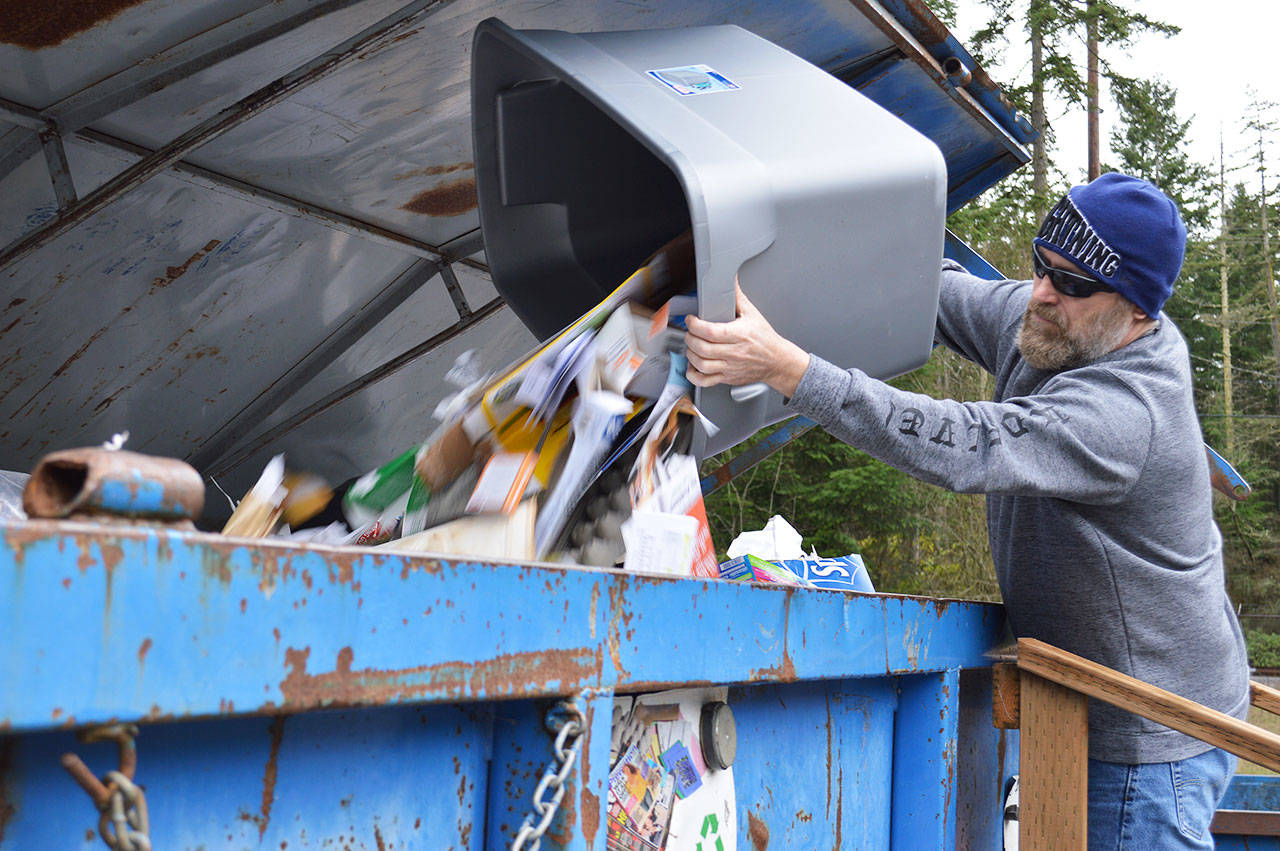 Keith Woodman dumps his mixed paper into the bin at the recycle center in Coupeville. Washington state faces a problem of having too much contaminated material, which is something Rep. Norma Smith, R-Clinton, aims to address in her recent bill. Photo by Laura Guido/Whidbey News-Times